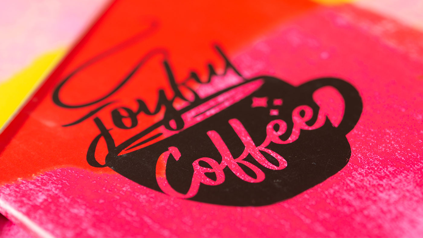 Closeup detail of packaging showing bold Joyful Coffee illustration 