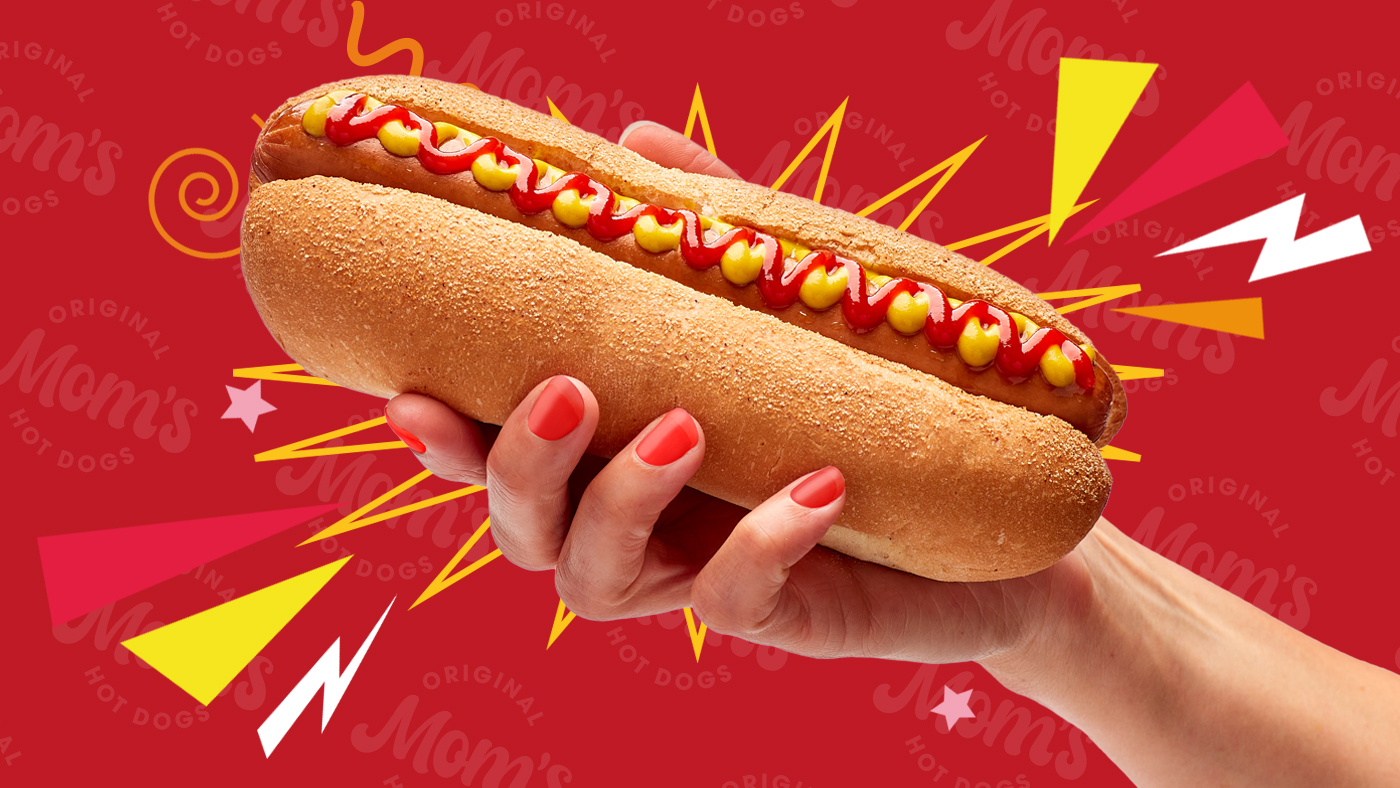 Hand holding hot dog with graphic background